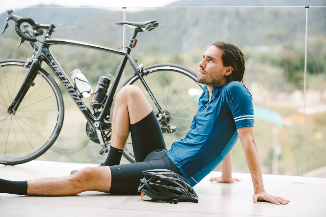 Un homme assis à côté de son vélo