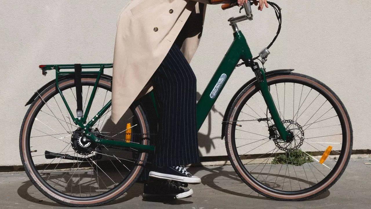 Une femme à côté de son vélo de ville électrique