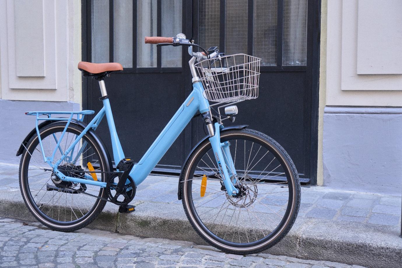 Un vélo folio sur une route en pavée devant une porte noire