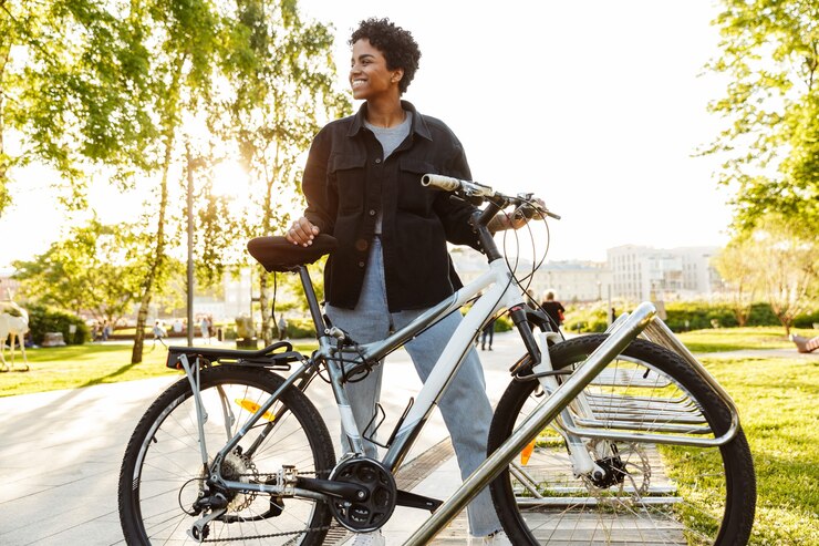 Une femme avec son vélo dans les mains sur une route