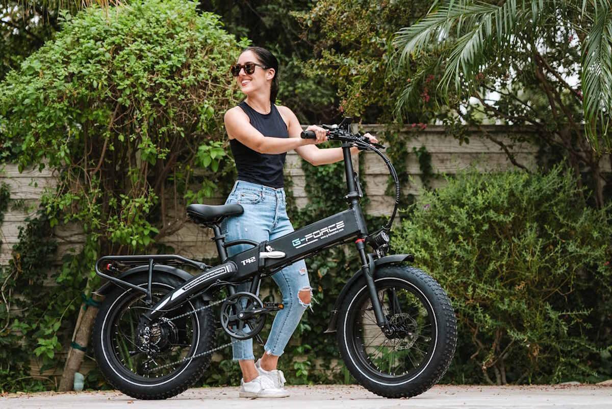 Une femme sur un vélo devant de la verdure